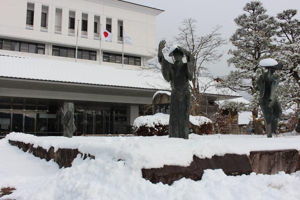 踊りのポーズをとっている銅像に雪が積もっている写真