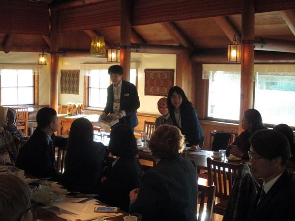 椅子に市長が座り、小山さん、小林さんが立って皆様方にお話ししている写真