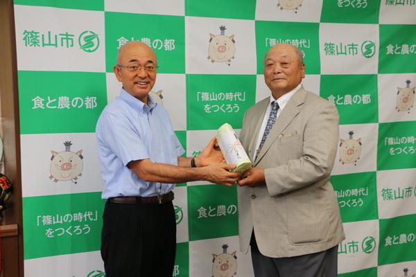 井関 道夫（いせき みちお）さんが、市長に寄付を渡している写真