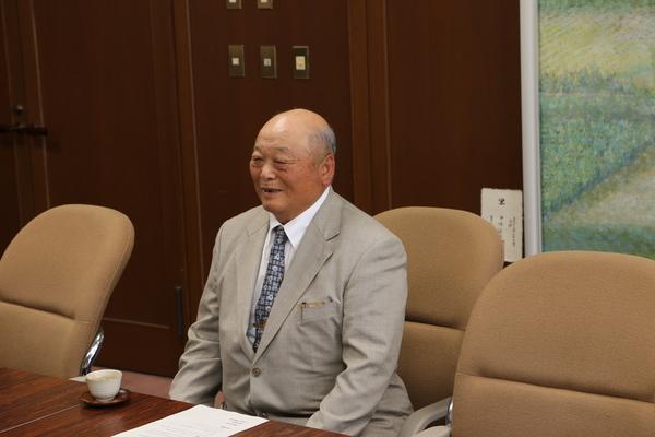 曽地奥にお住まいの井関 道夫（いせき みちお）さんが座り、話をしている写真