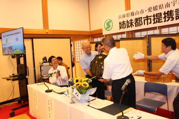 市長が男性から 漁師の瓶玉を受け取っている写真