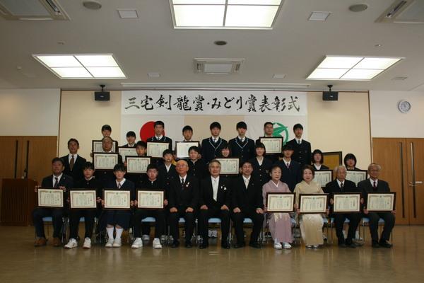 三宅剣龍賞、みどり賞の表彰式と書かれた幕の前で25名ほどの人たちが表彰状を持って市長と一緒に記念撮影をしている写真
