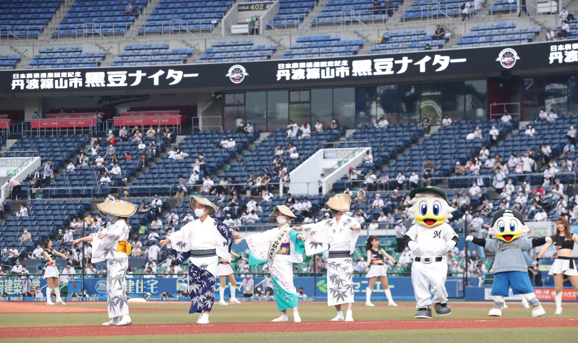 球場で編み笠をかぶってデカンショ浴衣を着て輪になってデカンショを踊っている