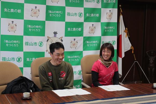 市民ランナーの森田 大介さんと中野 章子さんが笑顔で机に並んで座っている写真