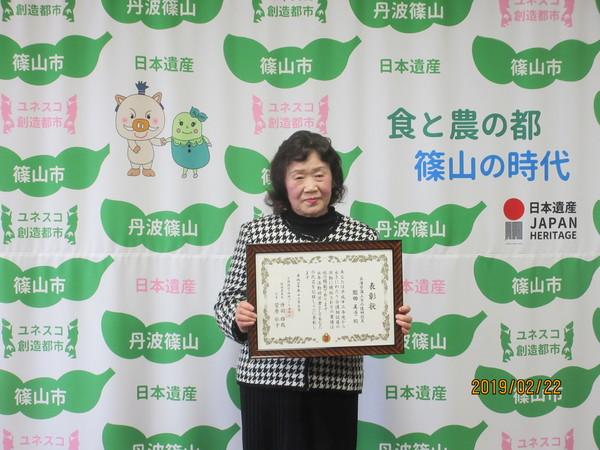 園田さんが表彰状を持って立っている写真