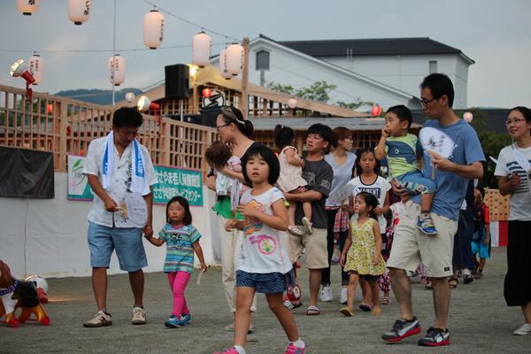祭り会場でたくさんの家族が歩いている写真