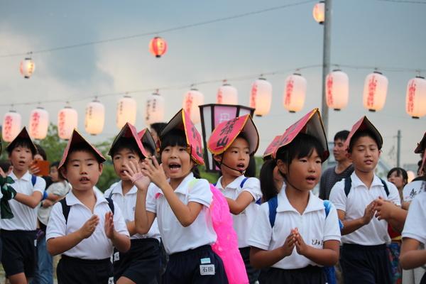 制服を着た子供達が篠山と書かれた手作りの帽子を被って踊っている写真