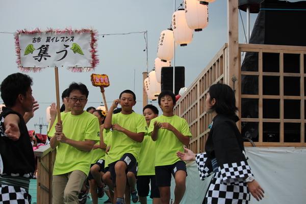 プラカードを持った男性の後ろを子供達が歩いている写真