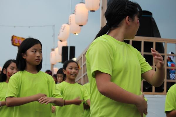 黄緑のティシャッを着た女の子たちが踊っている写真