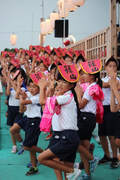 子供達が踊りを踊りながら舞台の坂を下りている写真