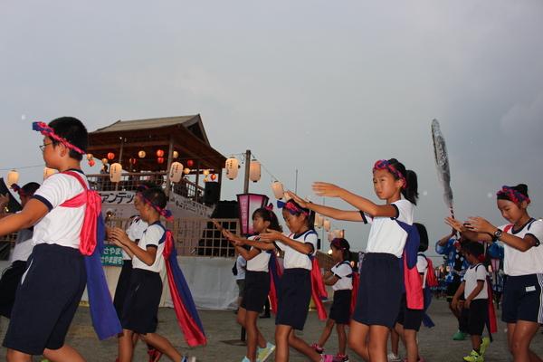 大きな舞台の周りを子供達が踊っている写真
