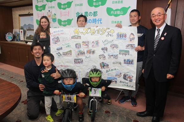 キッズライダーのメンバーと市長が、紹介の模造紙をもって笑っている写真