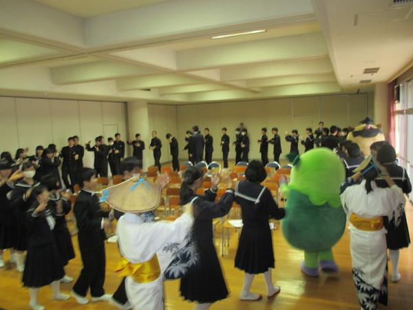 中学生やまるいのの着ぐるみ達が円になって盆踊りを踊っている写真