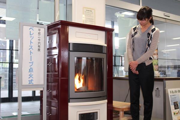 ペレットストーブに点火されたのを見ている布施 未恵子さんの写真