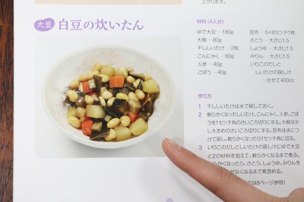 左側には白豆の炊いたんの文字と、大豆、人参、昆布などの入った炊いたんの写真、右側には材料と作り方が載っているレシピの写真