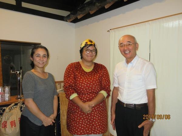 民宿内で3人の大人の男女が正面をむいている写真