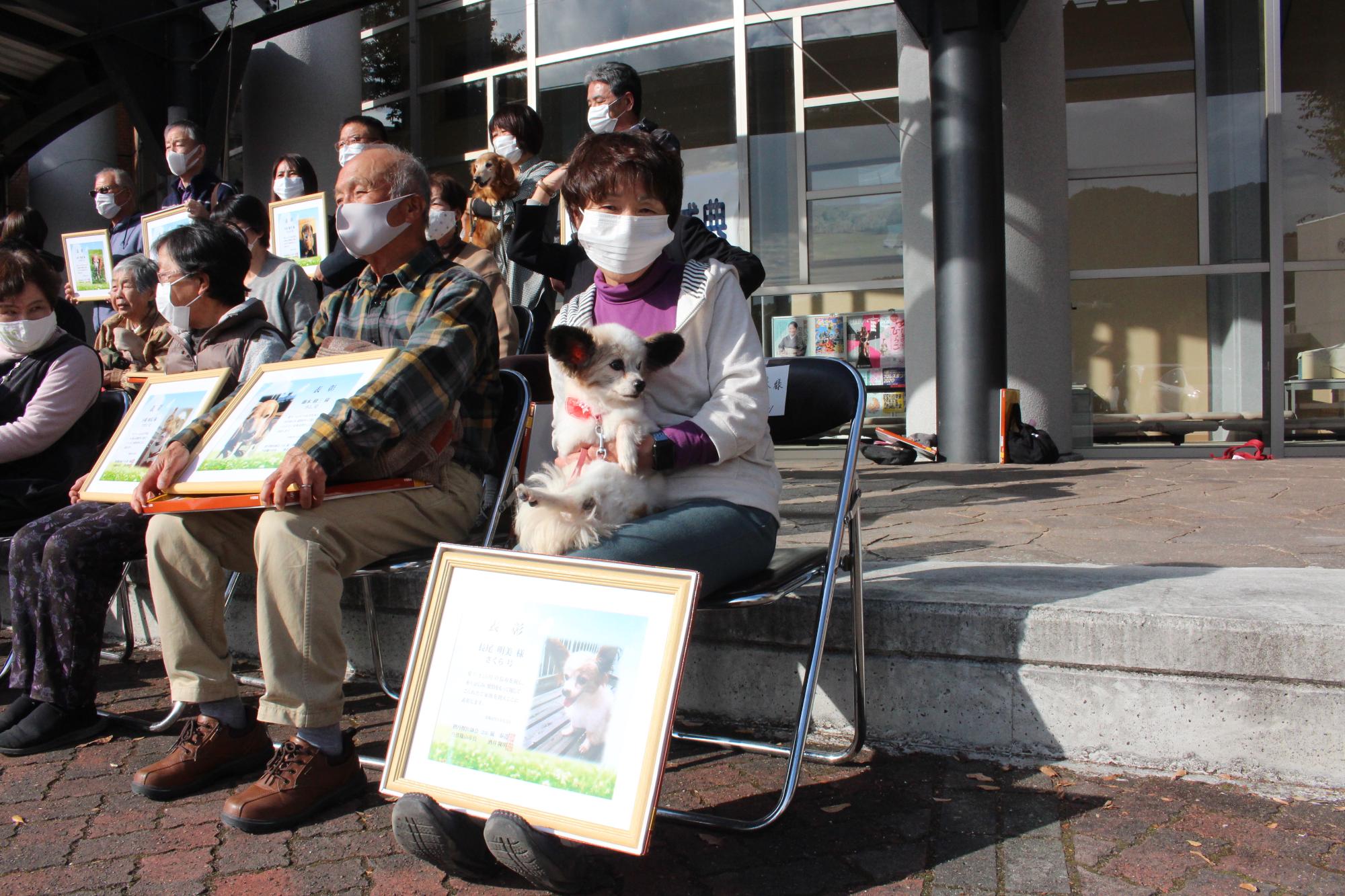 膝の上で飼い犬を抱いている飼い主