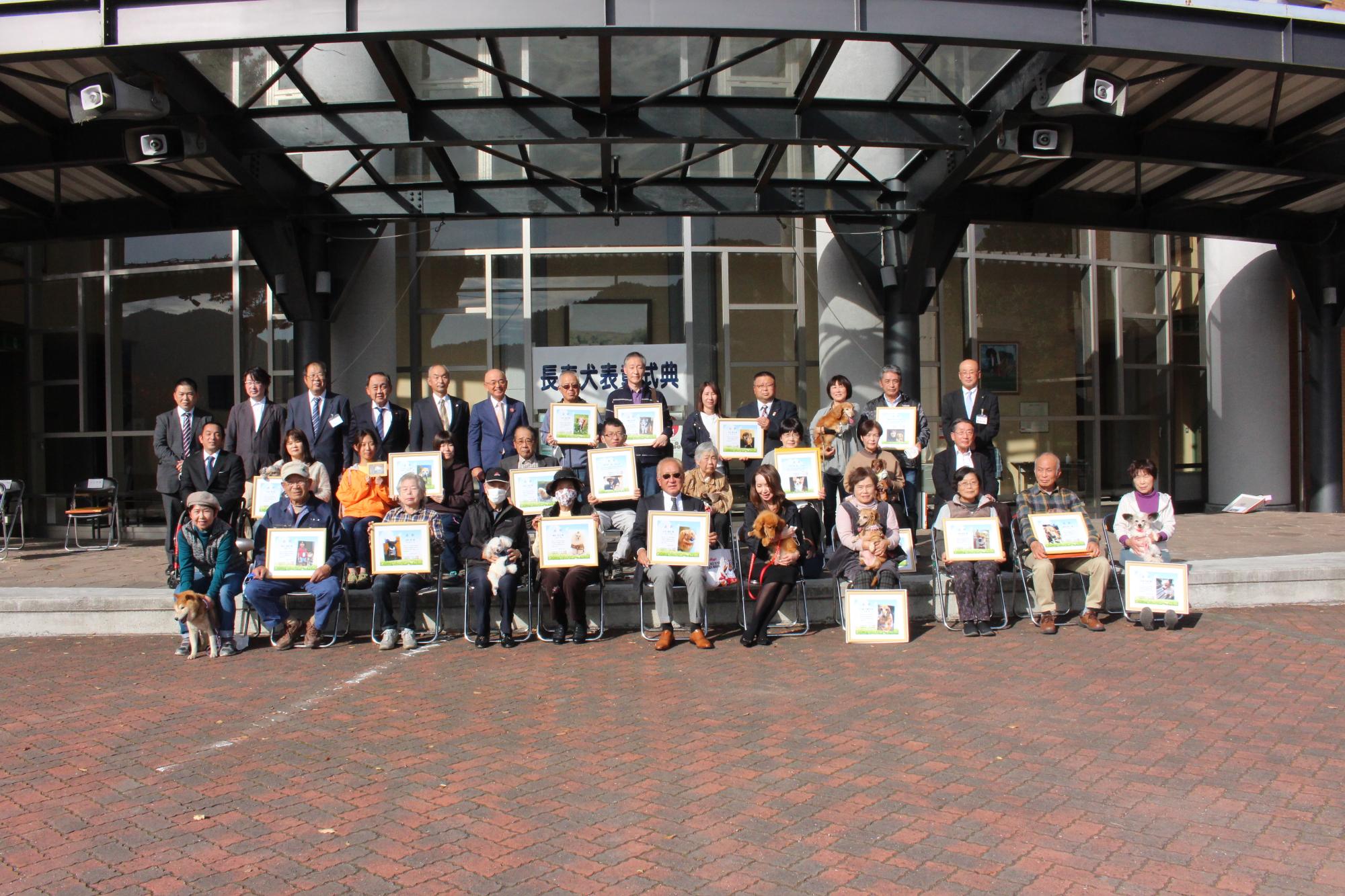 飼い犬と一緒に記念撮影をする飼い主