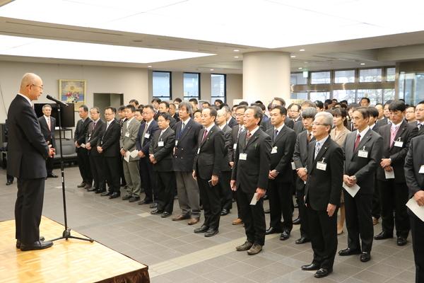 多くの職員が整列している前で壇上でマイクに向かって市長が話をしている写真