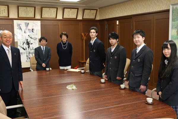 市長室の大きなテーブルを挟み、篠山産業高校等学校丹南校の新生徒会役員4名と奥に教頭先生と生徒会担当の先生、左側に市長が立っている集合写真