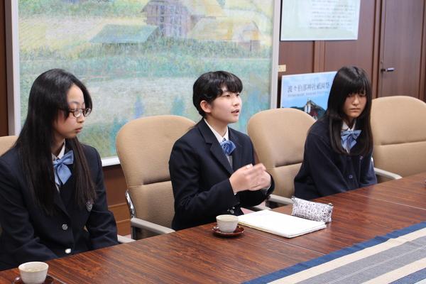 報告に参加した女子生徒3名が椅子に座り、尾崎 夏鈴さんが代表でお話をしている写真