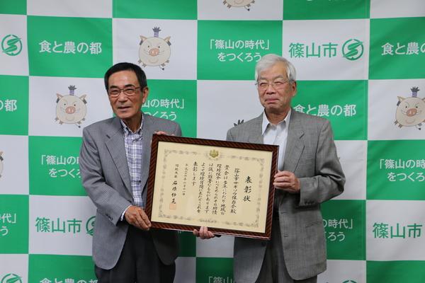 額縁に入った表彰状を2人で持って笑顔で写っている谷口会長と檜皮さんの写真