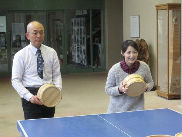 卓球台の前で熊谷 奈美さんと市長が桶を持って相手のボールを待っている写真