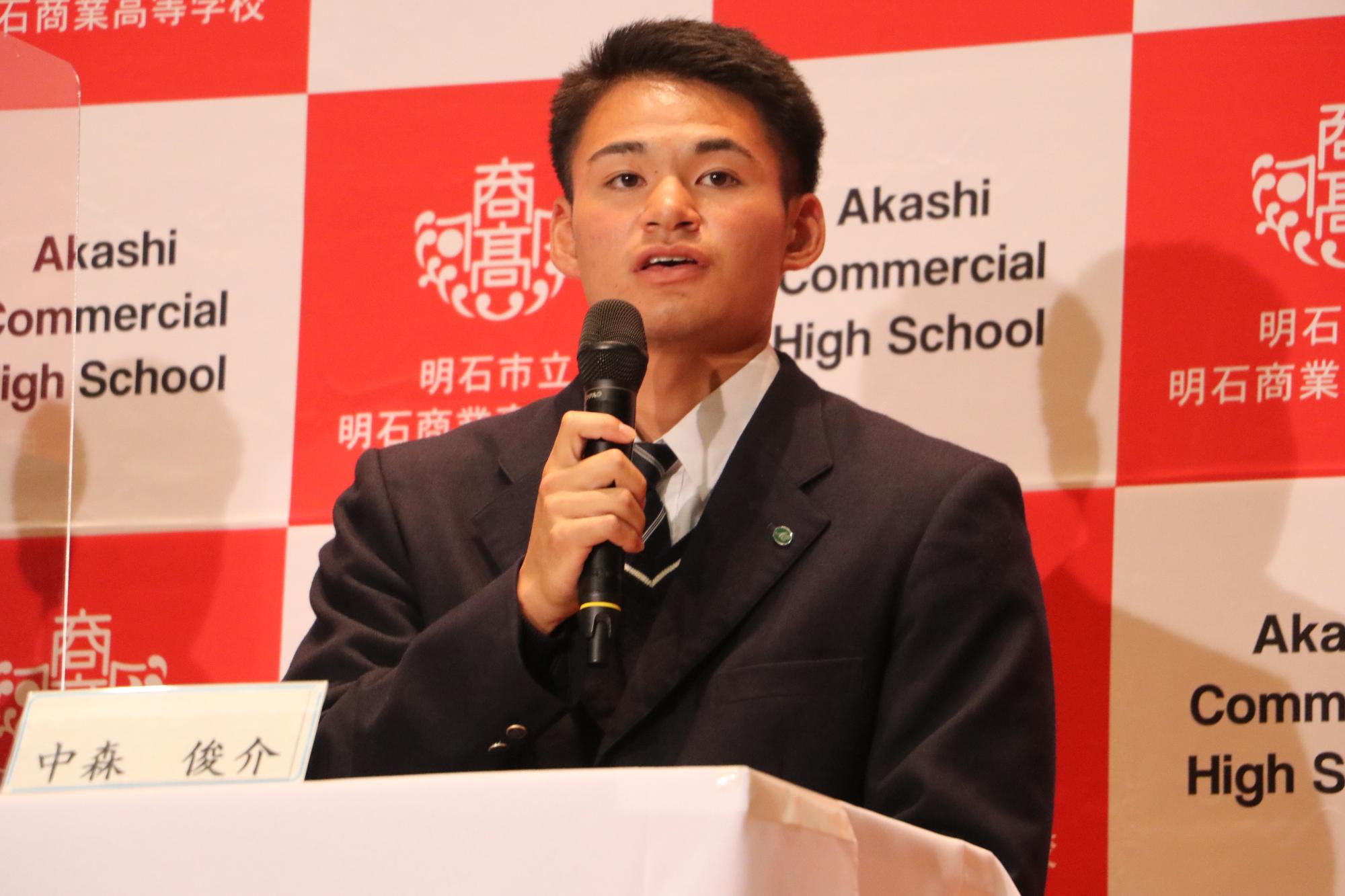記者会見でマイクを持って話している中森選手