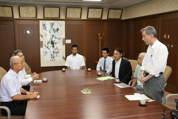 応接室にて着席しているスーツを着た複数の男性と市長の写真