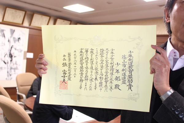 堀毛会長が賞状をアップで見せる写真