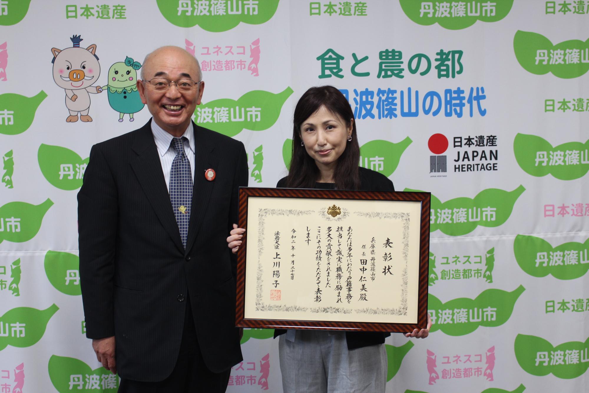 市長、表彰状を手に持つ田中さん