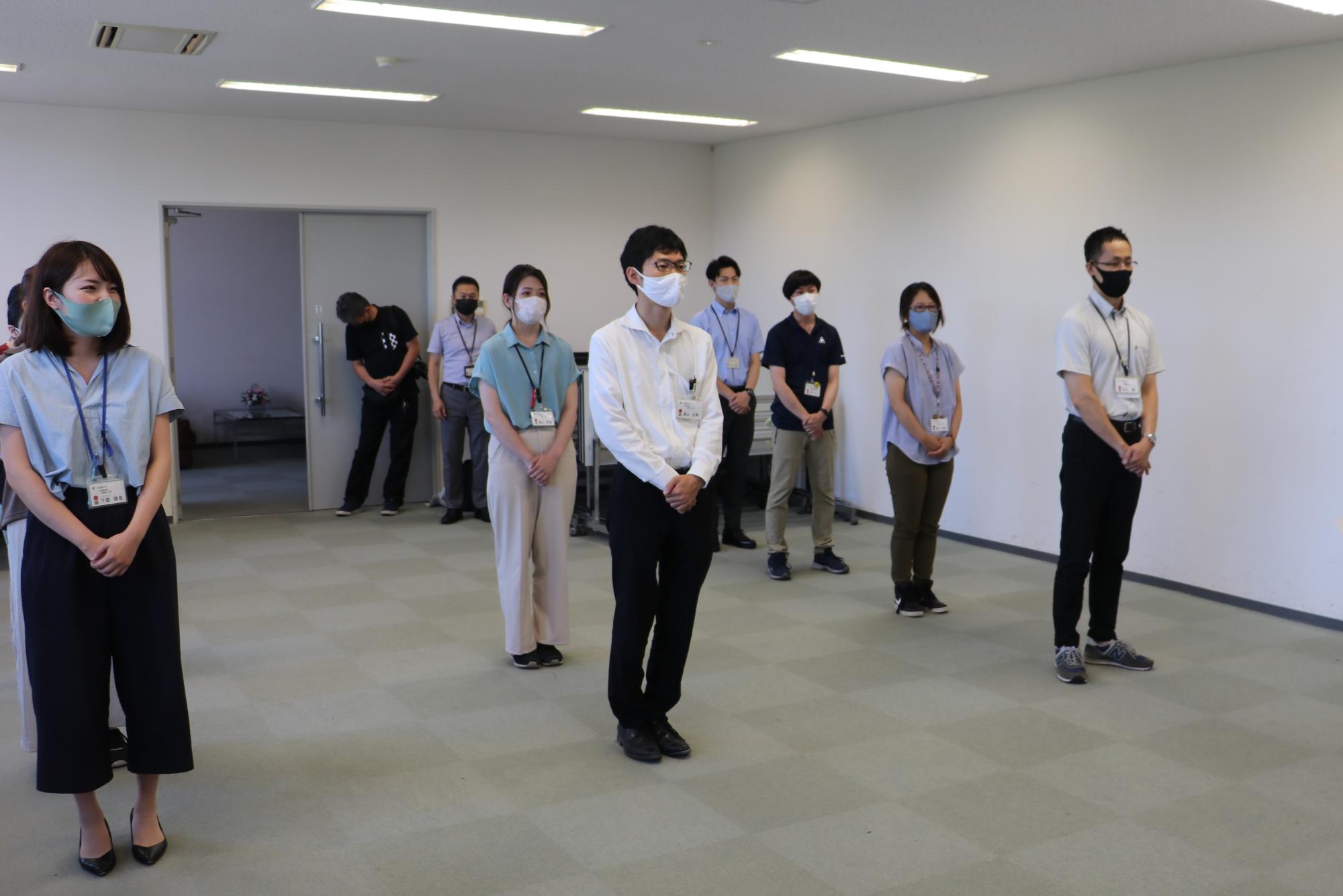 職員がプロジェクトチームごとに一列に並んでいる。