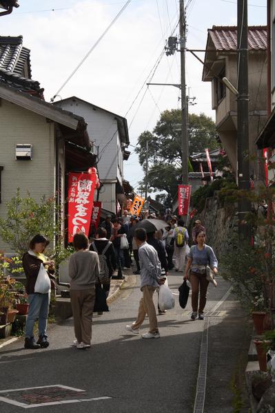 狭い路地に陶器祭りの旗が並び、たくさんの人でにぎわっていいる写真