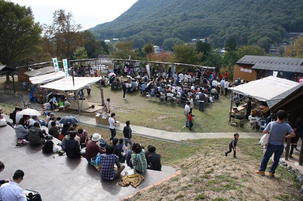 芝生の上に並べられた椅子や、階段に座る沢山の人々の写真