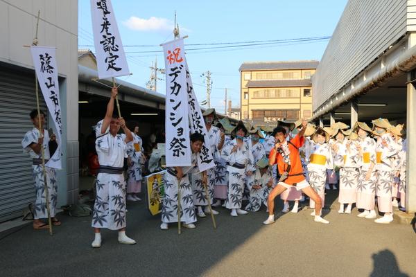 デカンショ祭の旗を持ち、浴衣に編み笠をかぶりそれぞれポーズをとっている集合写真