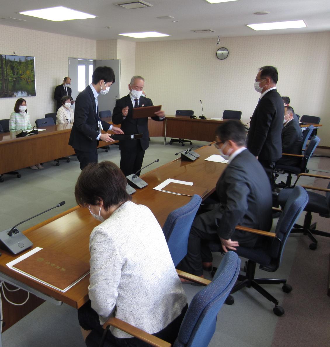 当選証書を手渡そうとする委員長