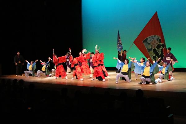 舞台上で、丹波篠山楽空間のチームがポーズをとっている写真