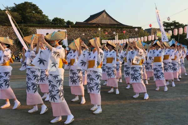 浴衣に、編み笠をかぶり踊っている女性の写真