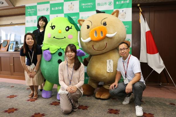 まるいのとまめりんの周りに集まる男女4名の集合写真