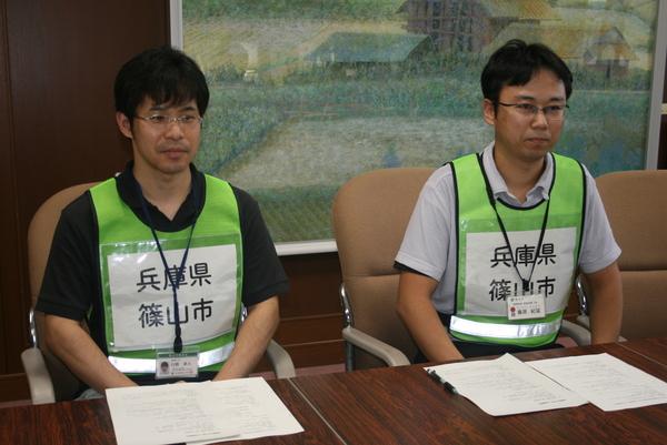 反射ベストを着用した、左に石原主査、その隣に藤原主査がすわっている写真
