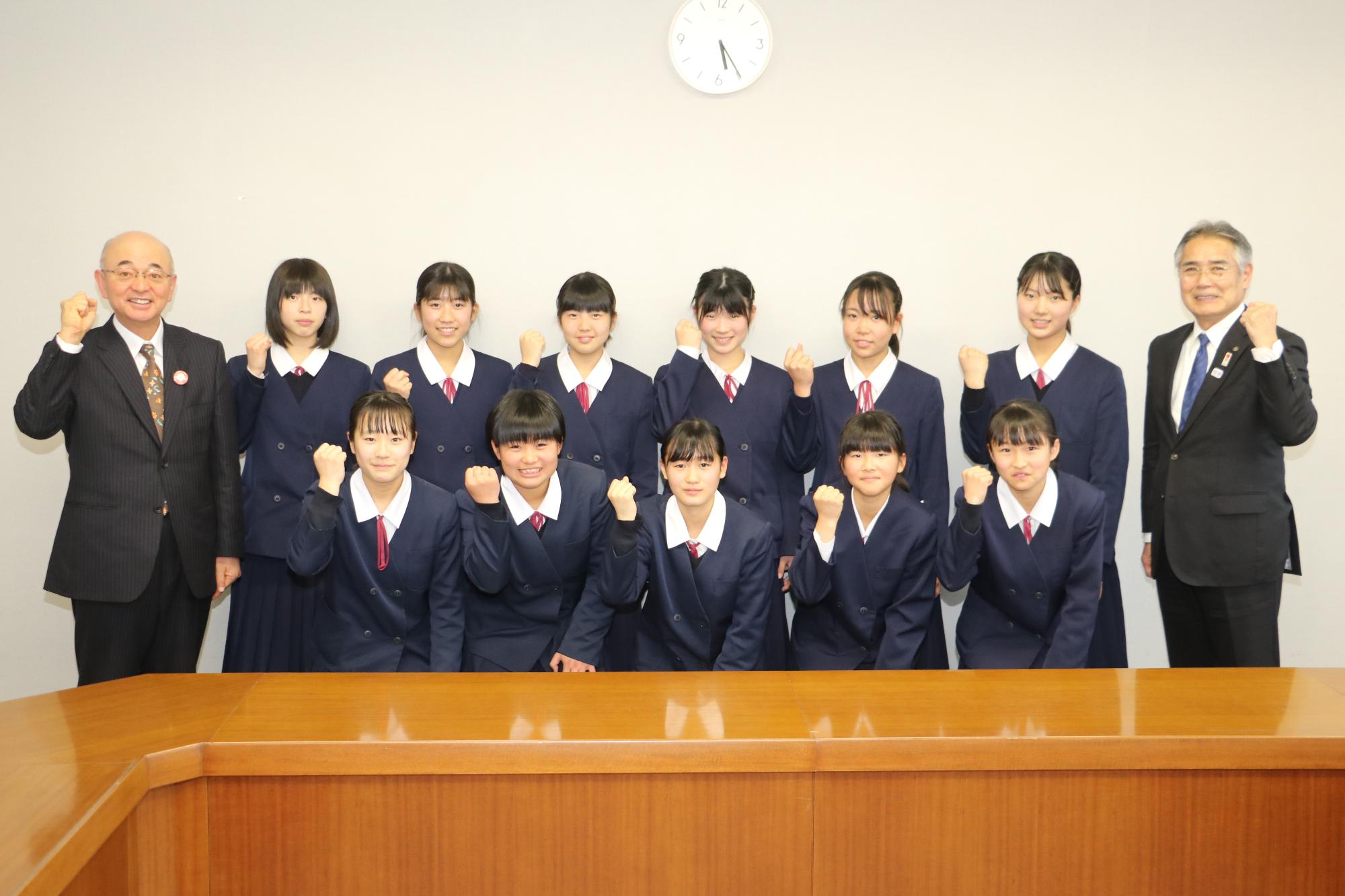 丹南中学校女子バレー部の生徒11名と、酒井市長と前川教育長が右手でガッツポーズをしている写真