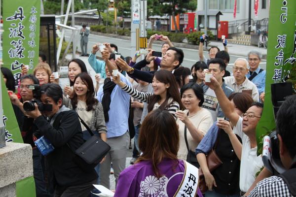 黒枝豆の販売解禁セレモニーに来られた方が紙コップを頭上にあげて乾杯している写真