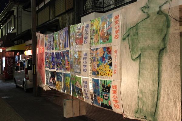 右側に城東小学校と書かれた子供たちの絵が12点ほど道路に飾られている写真