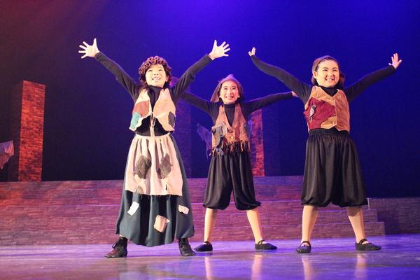 両手を広げ、笑っている3人の子供の写真