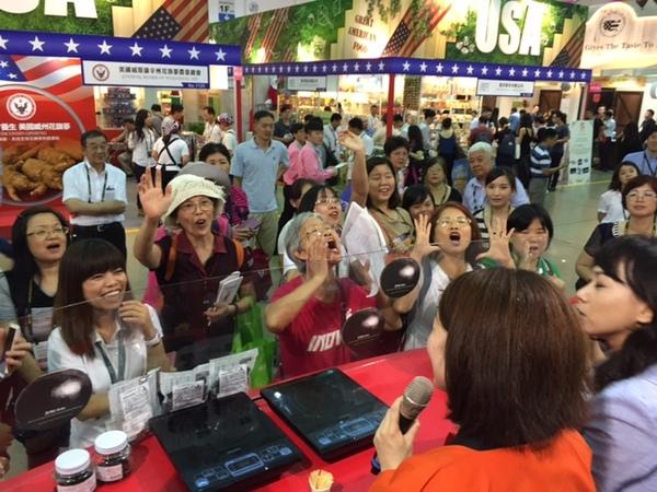 女性がマイクで話していて、たくさんのお客さんが「丹波の黒豆！！」と叫ばれている様子の写真