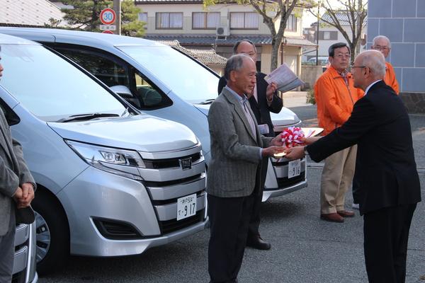 市長から西紀北ボランティアの方に鍵を渡され、緊張が伝わる写真