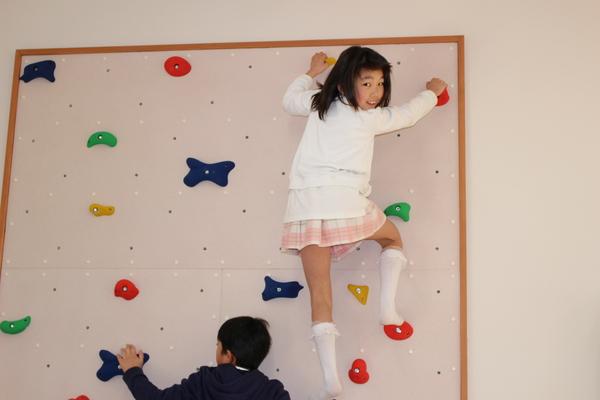 施設内のクライミングウォールを児童2名が登っている写真