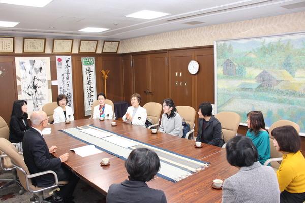 市長を10人の女性が座り、話をしている写真