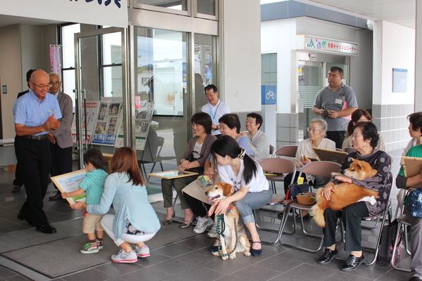 表彰状を受け取った親子を見て微笑んでいる市長や他の表彰者たちの写真