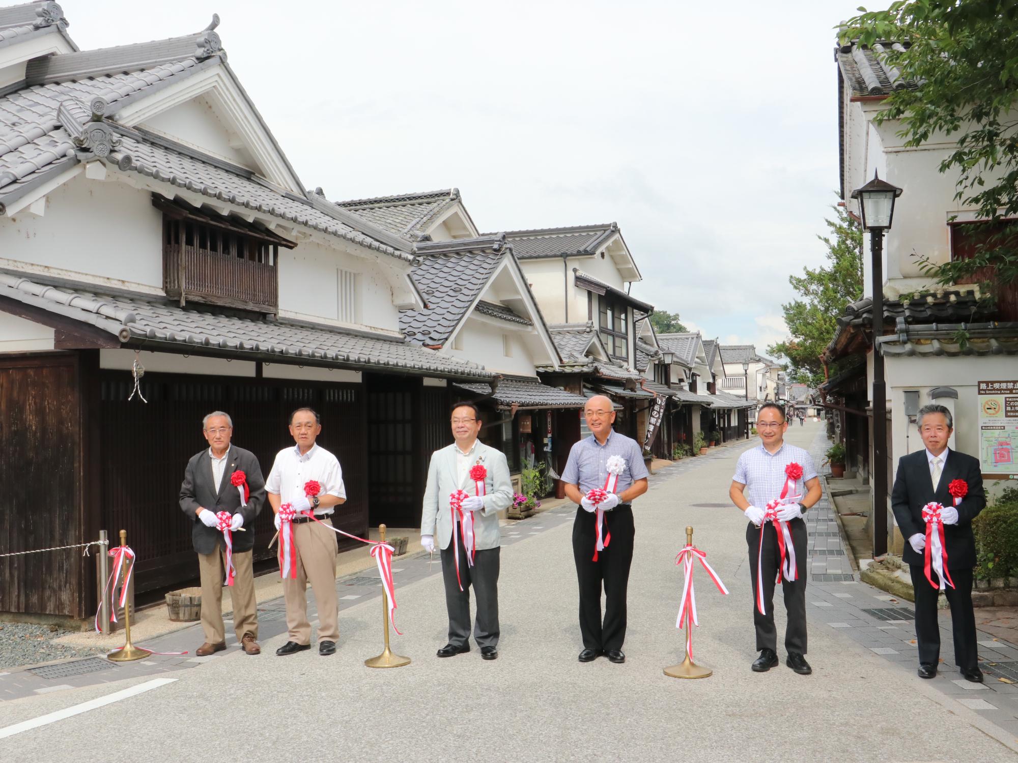 無電柱化工事が完成した河原町で、市長や県議会議員、市議会議員、地元の関係者など7名がテープカットしている。